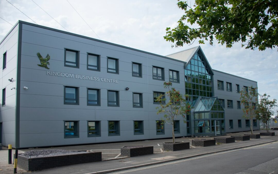 External view of the building - large grey building with lots of windows.