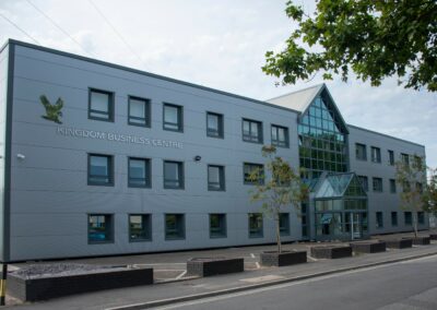External view of the building - large grey building with lots of windows.
