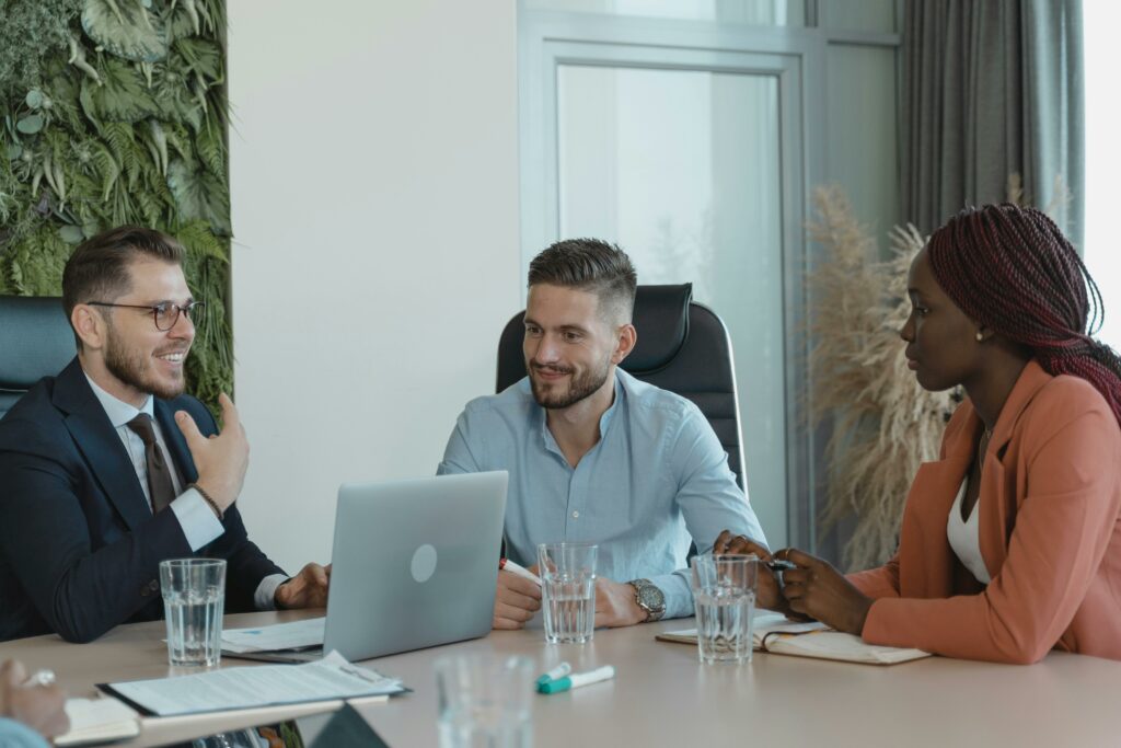 3 people having a meetingaround a laptio