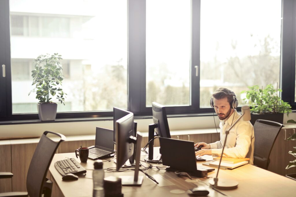 Man at computer with telephone headset on.